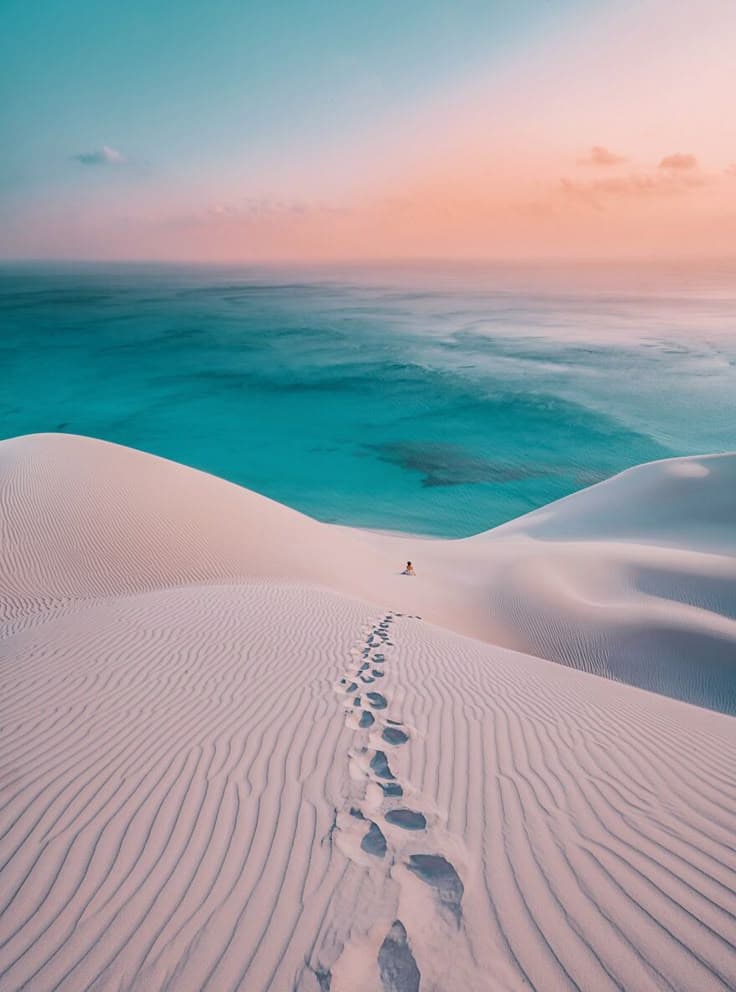 Warm sunset light over white dunes and turquoise water